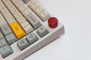 Beyaz arkaplanda parlak Enter tuşuna sahip beyaz mekanik klavye, minimalizm, klavye tuşları. Sarı tuşlu bir klavye. Yüksek kalite