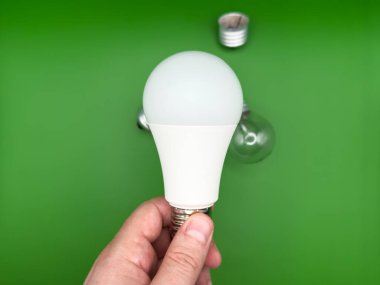 Modern LED lamba, elektrik tasarrufu. Tungsten ampul lambası. Çalışmayan ampul, kırık ampul. Işık ve karanlık kavramı, fikir, elektrik kopyalama alanı, yeşil arkaplan. Yüksek kalite