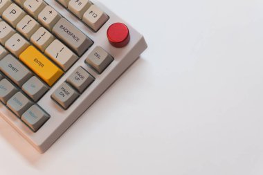 Beyaz arkaplanda parlak Enter tuşuna sahip beyaz mekanik klavye, minimalizm, klavye tuşları. Sarı tuşlu bir klavye. Yüksek kalite