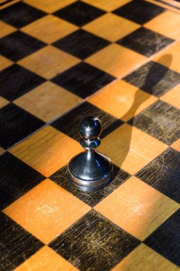 Tahtadaki satranç taşları, beyaz taşların arasında siyah bir piyon, farklı ve özel, önce siyah hamleler, kazanan oyun, satranç turnuvası, dünya satranç şampiyonluğu. Yüksek kalite