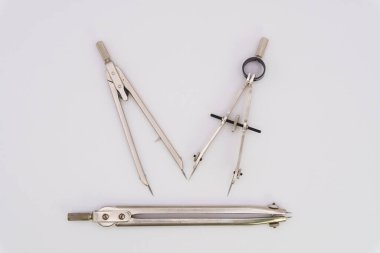 Gümüş renkli metalden yapılmış beyaz arka planda pusula çiziyor. Yüksek kalite