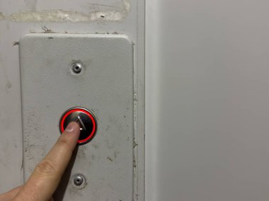 Bir adam eski bir evde asansör çağırma düğmesine, gümüş asansör çağrı düğmesine basar. Yüksek kalite