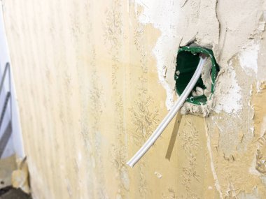 Soket için boş bir yer, tadilat sırasında duvardan sarkan kablolar, gelecekteki bir soket, apartman yenileme. Yüksek kalite