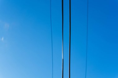 Elektrik kabloları mavi gökyüzüne karşı, siyah kablolar, modern teknoloji. Yüksek kalite