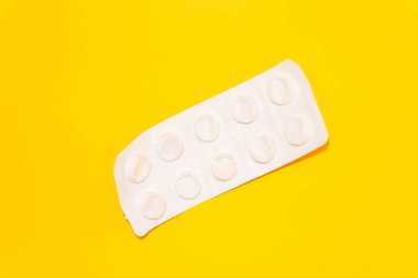 Boş hap paketi, sarı arka plan, virüs ve hastalık, hap tedavisi, hap zehirlenmesi veya aşırı doz, süresi geçmiş ilaçlar, fotokopi alanı, deri yüzme, üst görünüm. Yüksek kalite fotoğraf