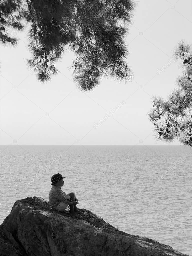 child on a rock by the sea