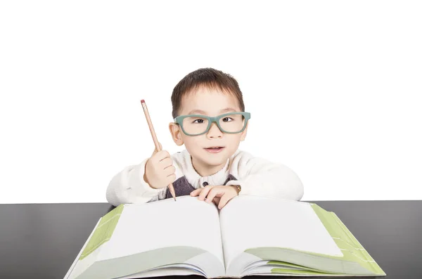 Шкільний хлопчик в окулярах вивчає книгу Ліцензійні Стокові Зображення