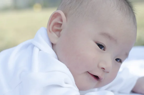 Baby liggend op het gras — Stockfoto