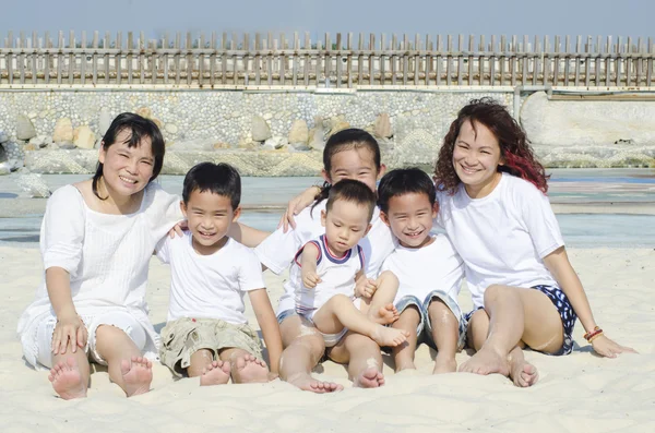 Família feliz sentada na praia — Fotografia de Stock