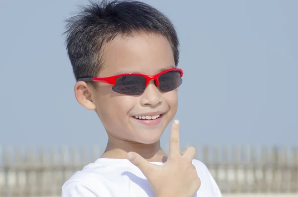 Jongen dragen van een zonnebril in de hemel — Stockfoto