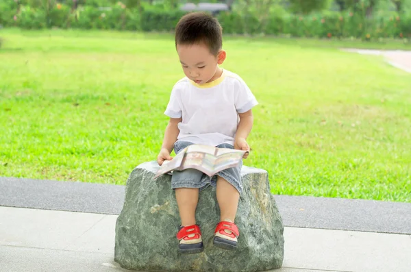 Junge liest gerne Buch im Freien — Stockfoto