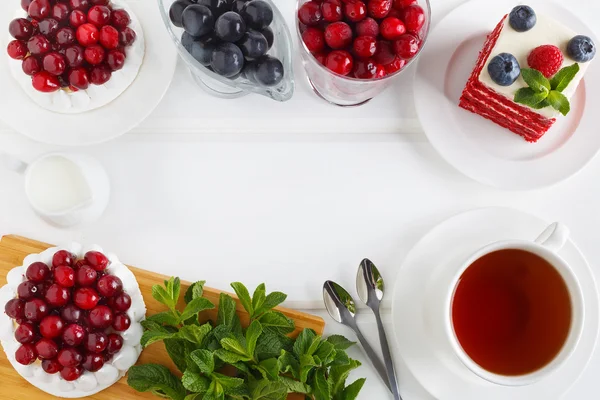 Üstten Görünüm krem ve çilek ile beze pasta Pavlova. Kırmızı kadife kek yaban mersini ve ahududu.