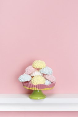 En az tarzı. Pastel pembe bir arka plan üzerinde renkli meringues