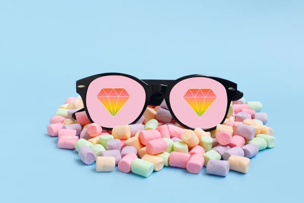 Üzerinde mavi bir arka plan üzerinde pastel hatmi trendy güneş gözlüğü. Renkli elmas simgeler moda güneş gözlüğü