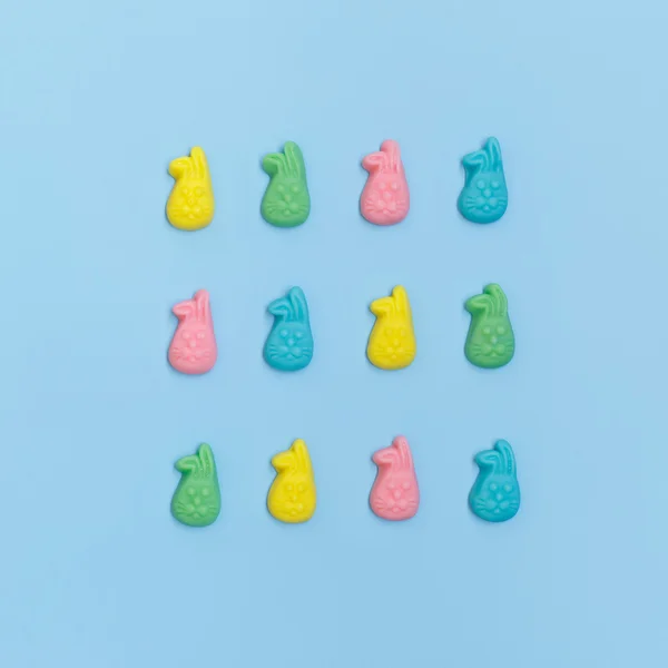 Barevné bonbóny v podobě králíků na světle modrém pozadí. Světlé barevné bonbóny mňam — Stock fotografie