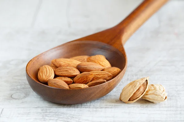 Hafif bir arka plan üzerine bir tahta kaşık kabuklu badem