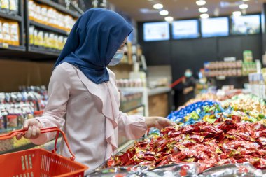 Yeni Normal kavram, alışveriş merkezindeki sevimli Malezyalı kız yüz maskesi takarak alışverişe gidiyor.