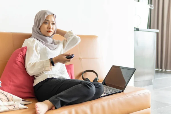 Lifestyle at home, cute malay woman at the sofa using laptop listening to the music