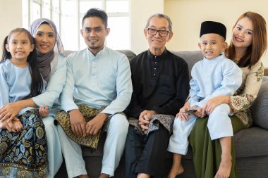Eid Mubarak celebration moment, family wearing traditional cloth smiling to the camera clipart