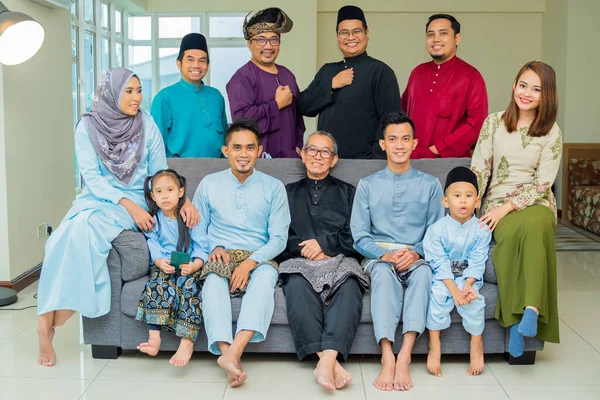 Eid Mubarak celebration moment, big family photo at the sofa wearing traditional cloth. Happy asian family