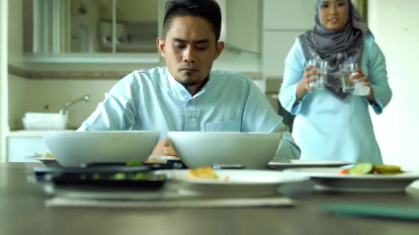 Eid Mubarakお祝いの瞬間 若い妻の夫のための食品ソフトフォーカスを準備する 幸せなアジア系家庭 主な科目は テーブルで待っている水と夫のガラスを保持妻です — ストック動画