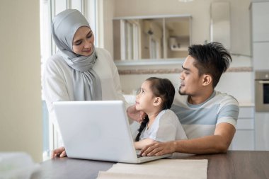 Aile hayatı kavramı, çocuk kucağında otururken evde çalışan baba ya da koca.