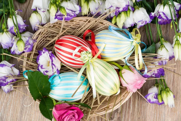 Πασχαλινά αυγά σε καλάθι με λουλούδια — Φωτογραφία Αρχείου