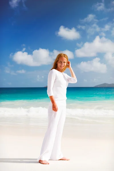 Vrouw staat op het strand — Stockfoto