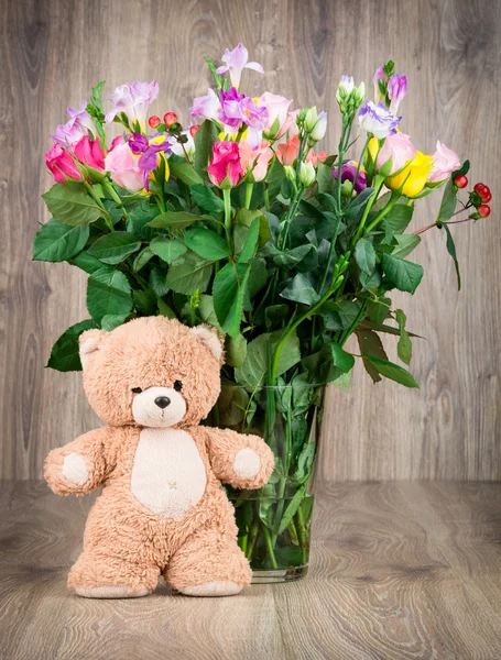 Urso de pelúcia e flores no vaso — Fotografia de Stock