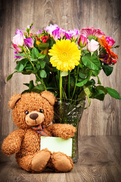 Urso de pelúcia e flores no vaso — Fotografia de Stock