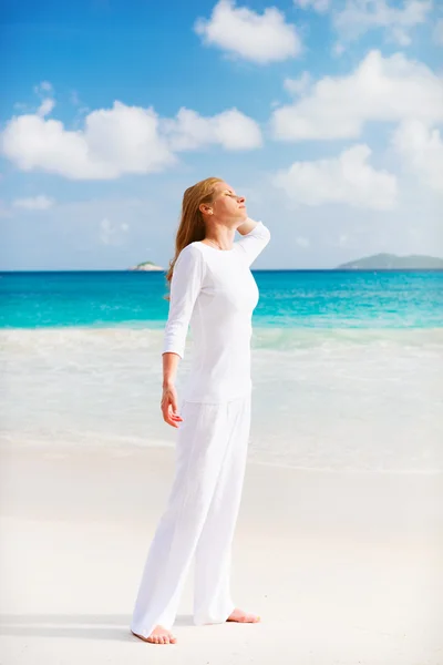 Vrouw staat op het strand — Stockfoto