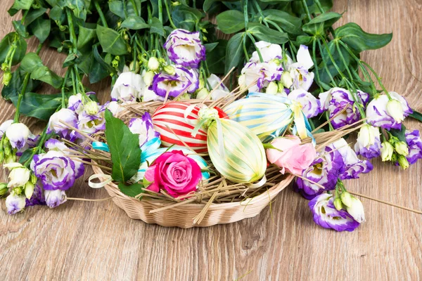 Пасхальные яйца в корзине с цветами — стоковое фото