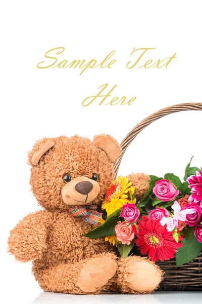 Blumen im Korb und ein Teddybär — Stockfoto