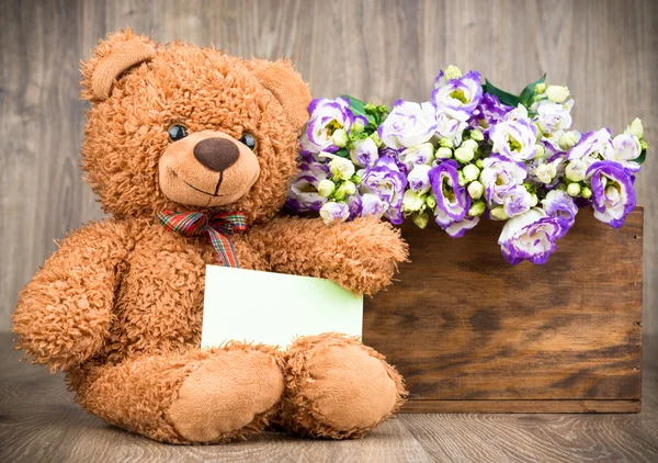 Flores na caixa e um urso de pelúcia — Fotografia de Stock