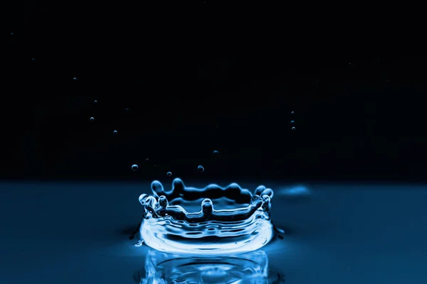 Water spatten op zwart — Stockfoto