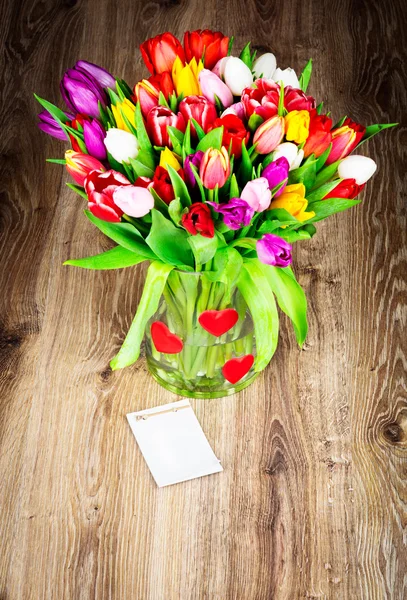 Jasny tulipany w wazonie szkła — Zdjęcie stockowe