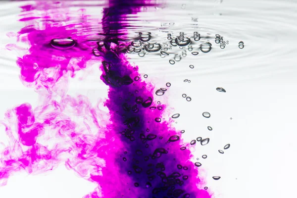 Pink paint splash in water