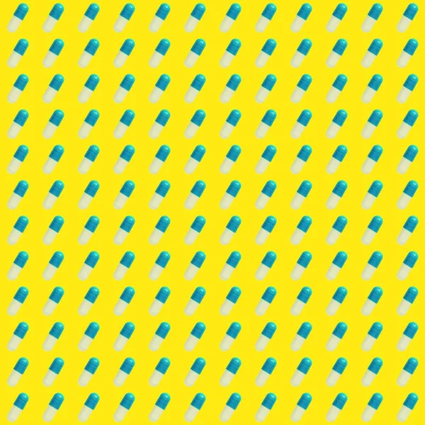 Sarı arka planda mavi hapların deseni