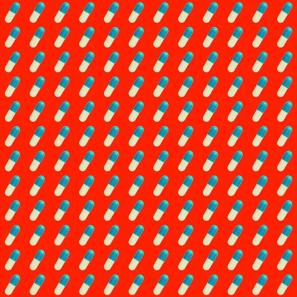 Kırmızı arkaplanda mavi hapların deseni