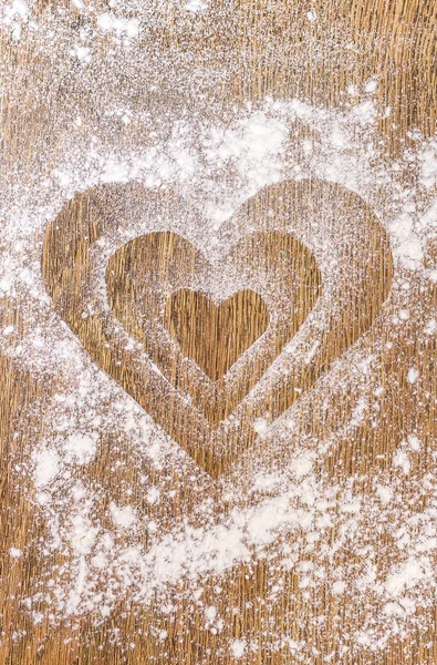 Форма сердца, сделанная из муки на столе — стоковое фото