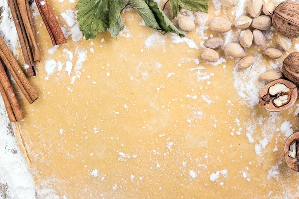 Background dough with nuts, cinnamon and flour — Stock Photo, Image