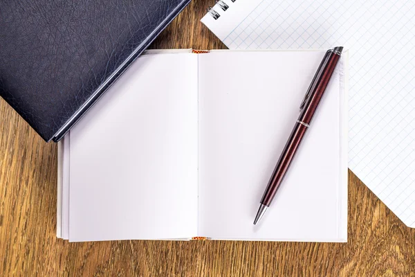 Notebook aperto con penna su sfondo desktop in legno — Foto Stock