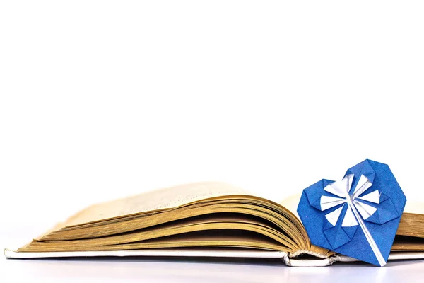 Open boek met blauwe origami hart — Stockfoto