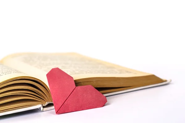 Libro abierto con corazón de papel rojo aislado sobre fondo blanco Fotos de stock libres de derechos