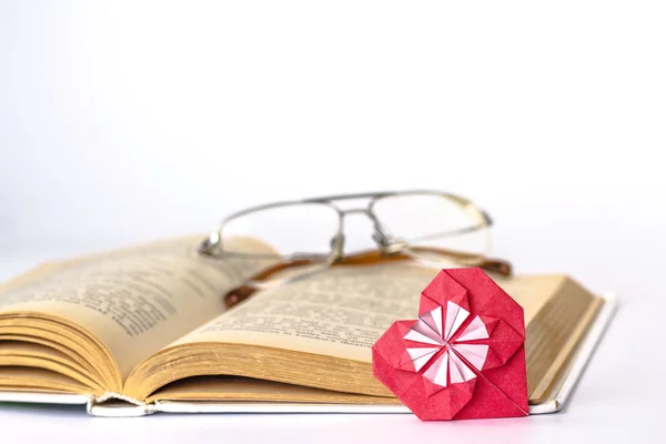 Livro aberto com coração de papel isolado no fundo branco — Fotografia de Stock