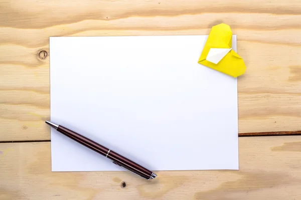 Tarjeta de San Valentín con corazón amarillo origami y bolígrafo sobre mesa de madera —  Fotos de Stock