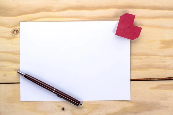 Valentines card with origami red heart and pen on wooden table — Stock Photo, Image