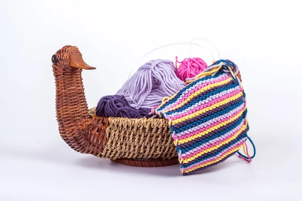 Striped knitted fabric in a basket with balls of wool — Stock Photo, Image