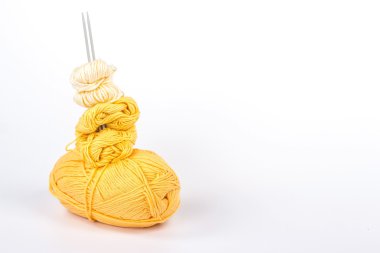 Birkaç topları sarı iplik örgü iğneleri ile izole yığını
