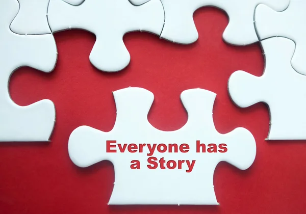 Puzzle pieces over red background with motivational quote "Everyone Has a Story" — Stock Photo, Image